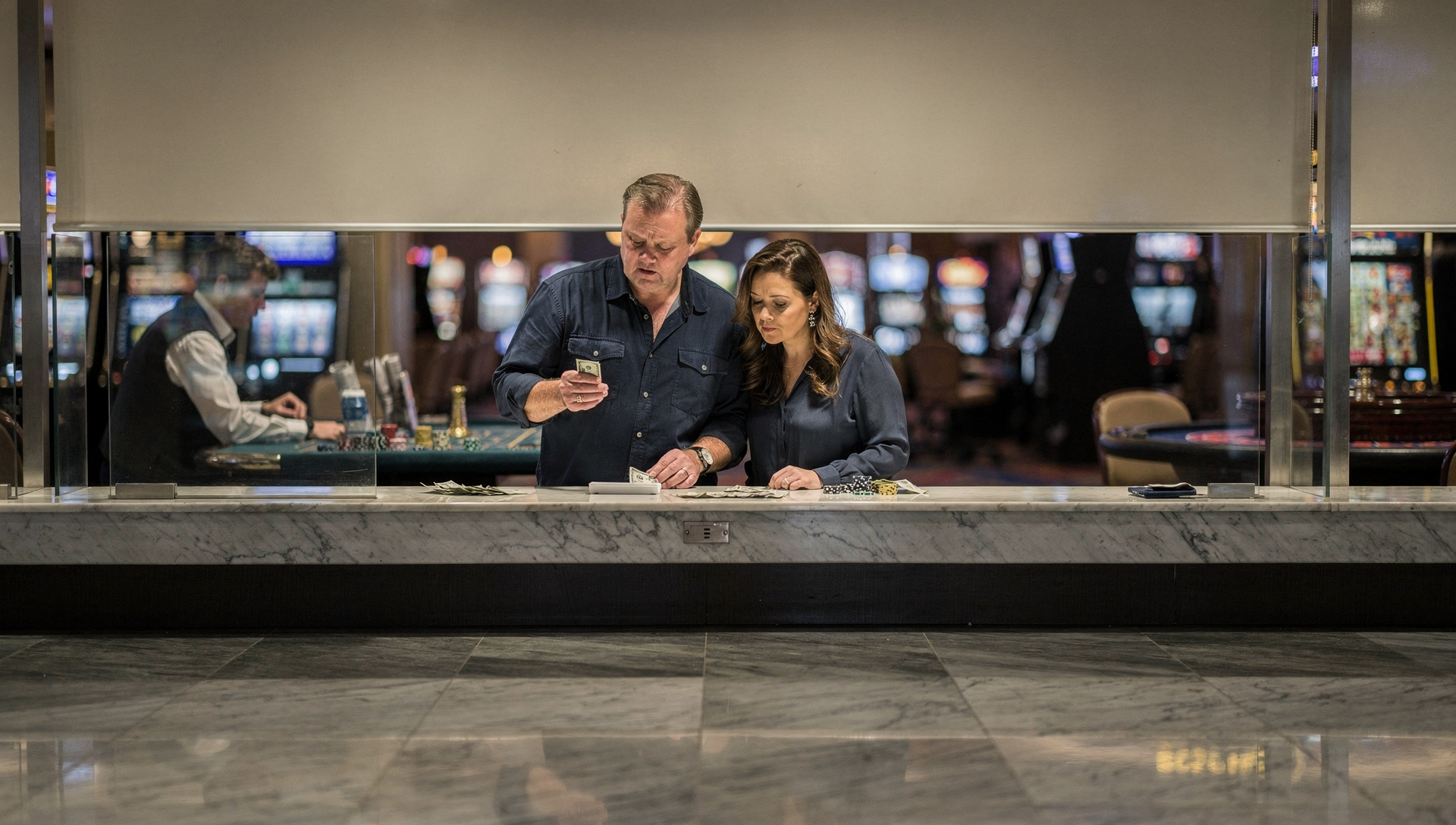 Canadian tourist reviewing federal and state casino tax withholding forms at a U.S. casino cage